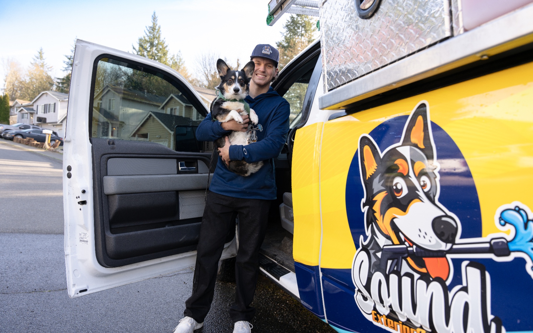 JJ, owner of Sound Exterior Solutions, with the company mascot dog