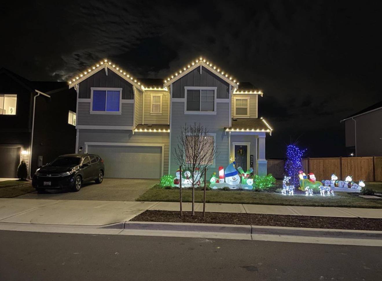 Craftsman home with warm white C9 roofline Christmas lights